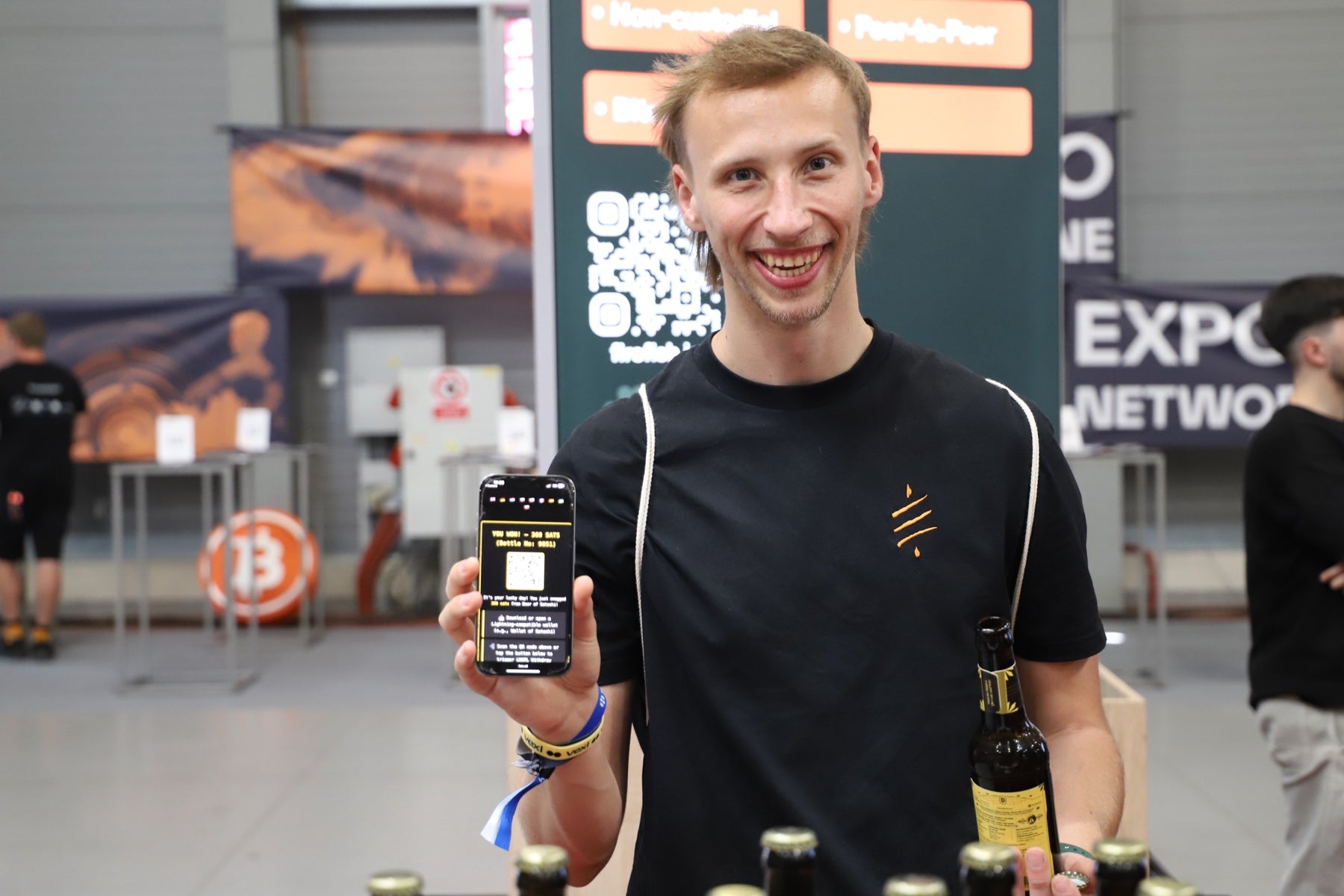 A BTC Prague visitor sharing a Beer of Satoshi bottle and its Bitcoin reward